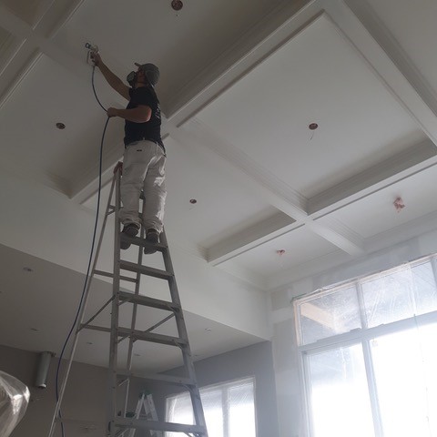 One of our employees painting the ceiling